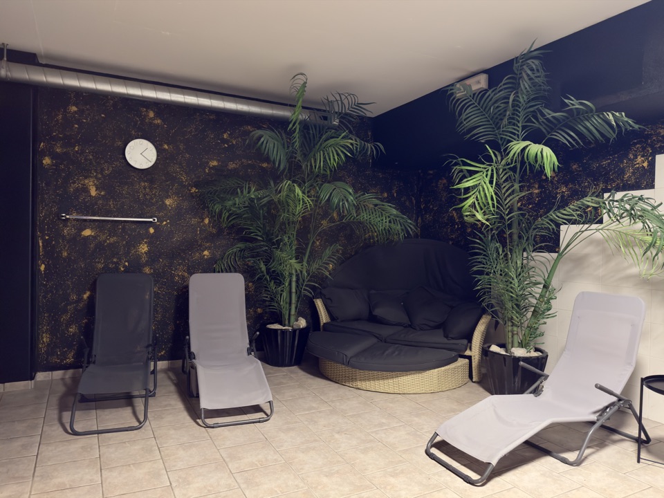 Ruheraum des 24Gym Thun mit Liegen und Pflanzen neben der Sauna